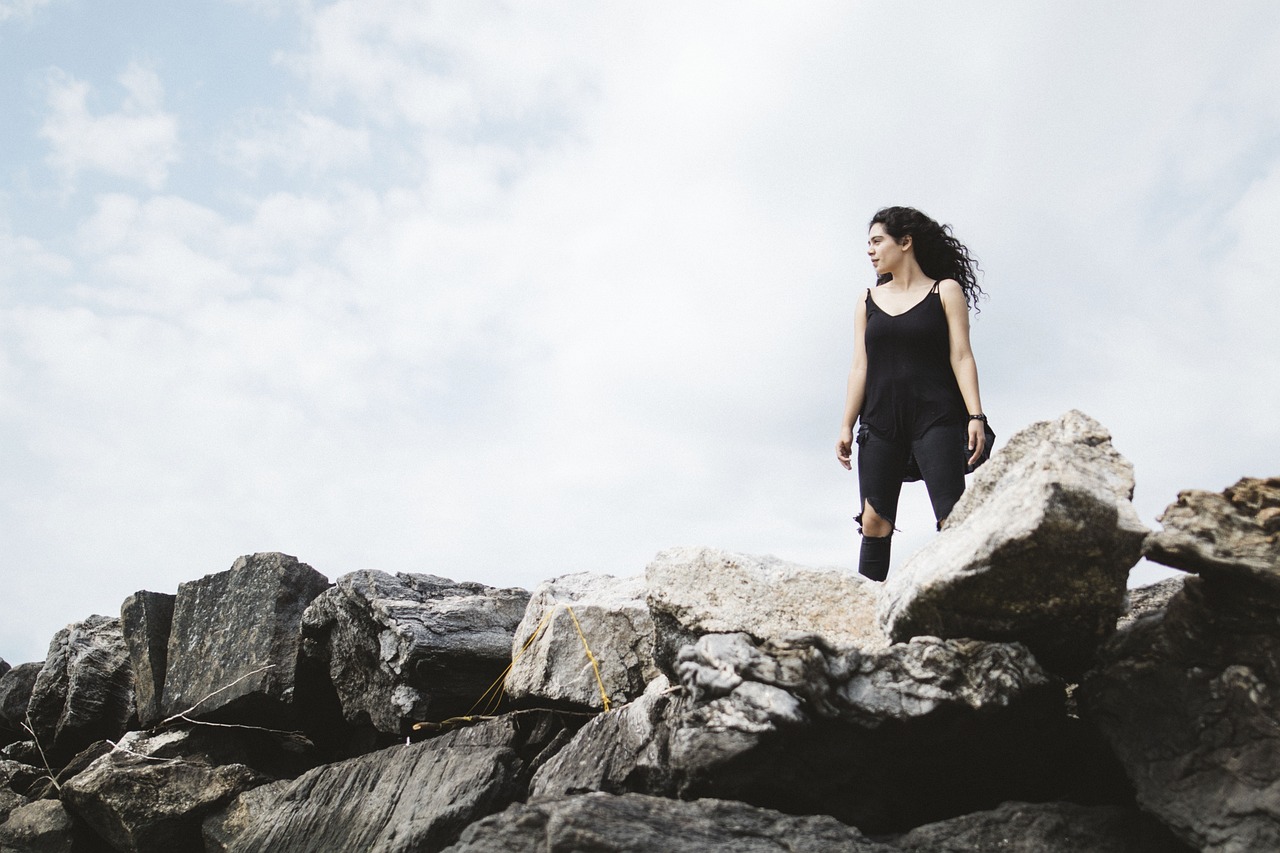 A girl on her own standing on top of a cliff